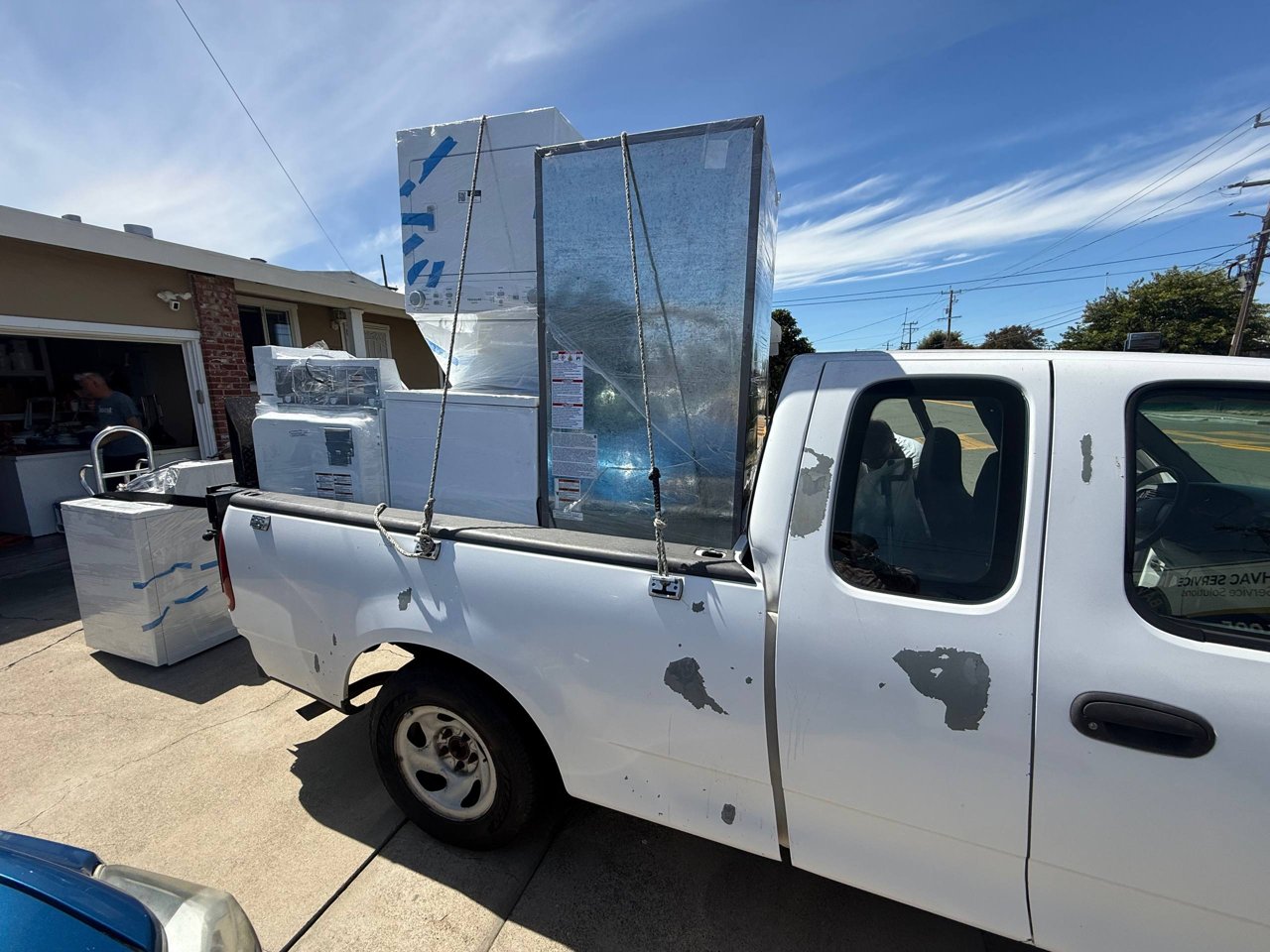 A pickup truck loaded with donated appliances wrapped for transport, ready to go to refugee families.